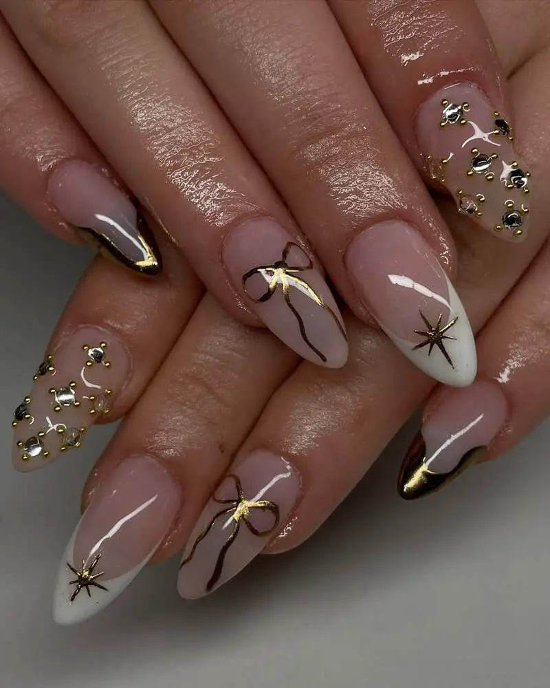 Nude nails with gold bows, stars and crystal details