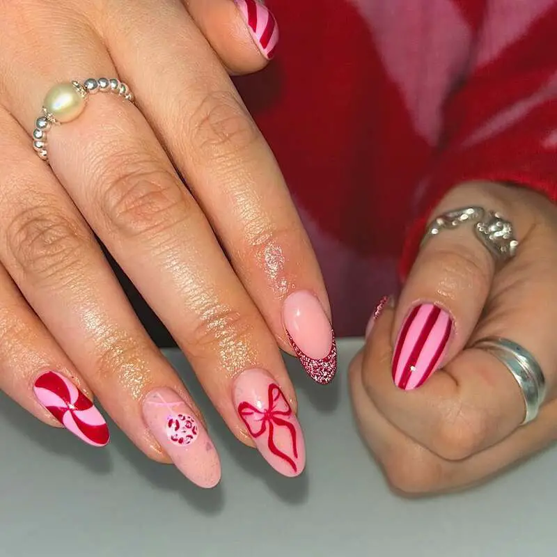 Pink and red holiday nails with peppermint swirls and bow designs