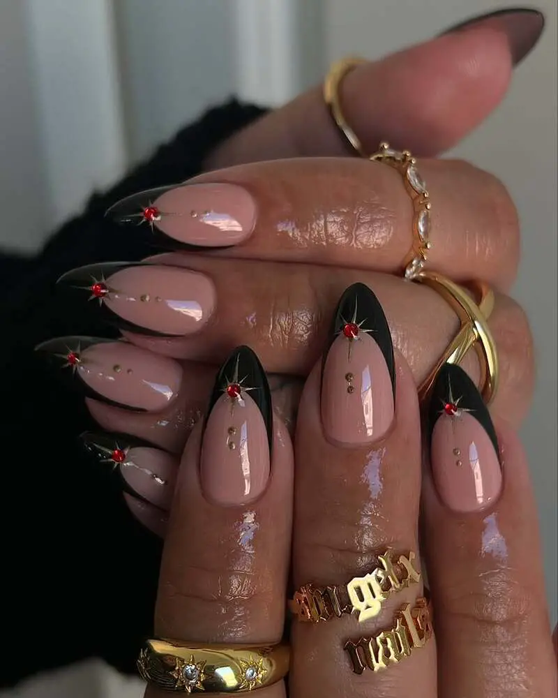 Nude nails with black French tips and red crystal accents