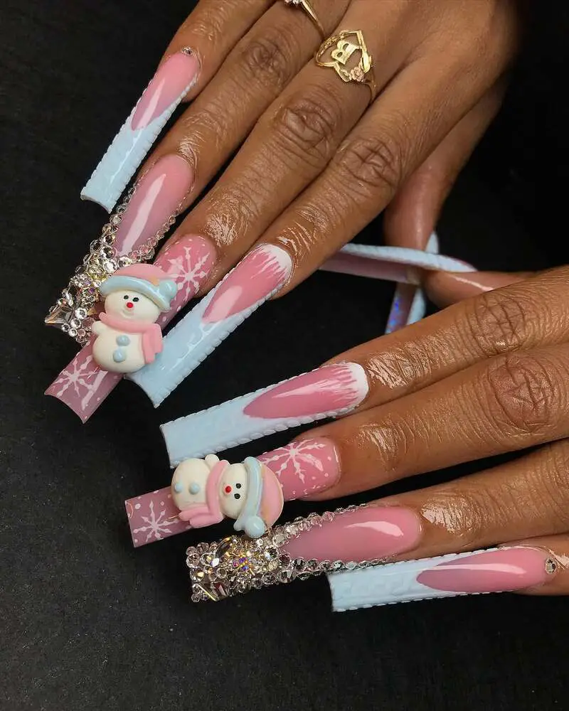 Long nails with pink and blue gradient, 3D snowman decorations, snowflake patterns, and crystal embellishments